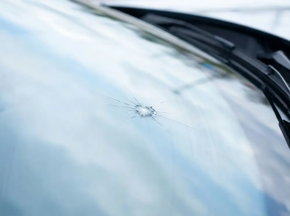 A small stone chip on a windscreen before repair